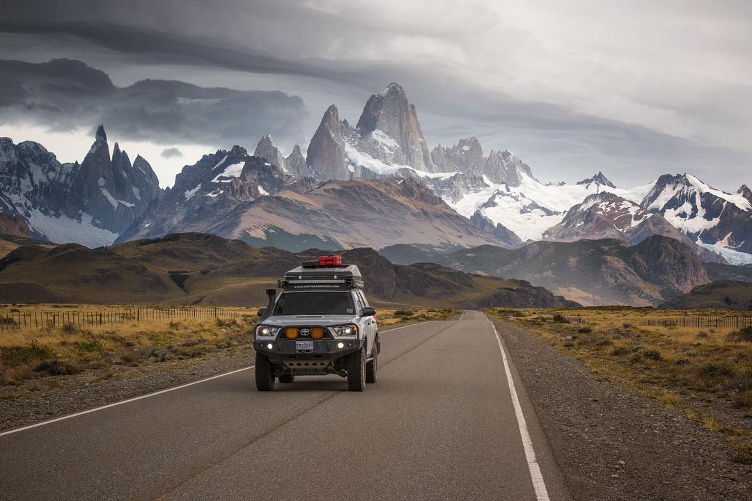 Camioneta de overlanding en la ruta, con la cordillera nevada al fondo